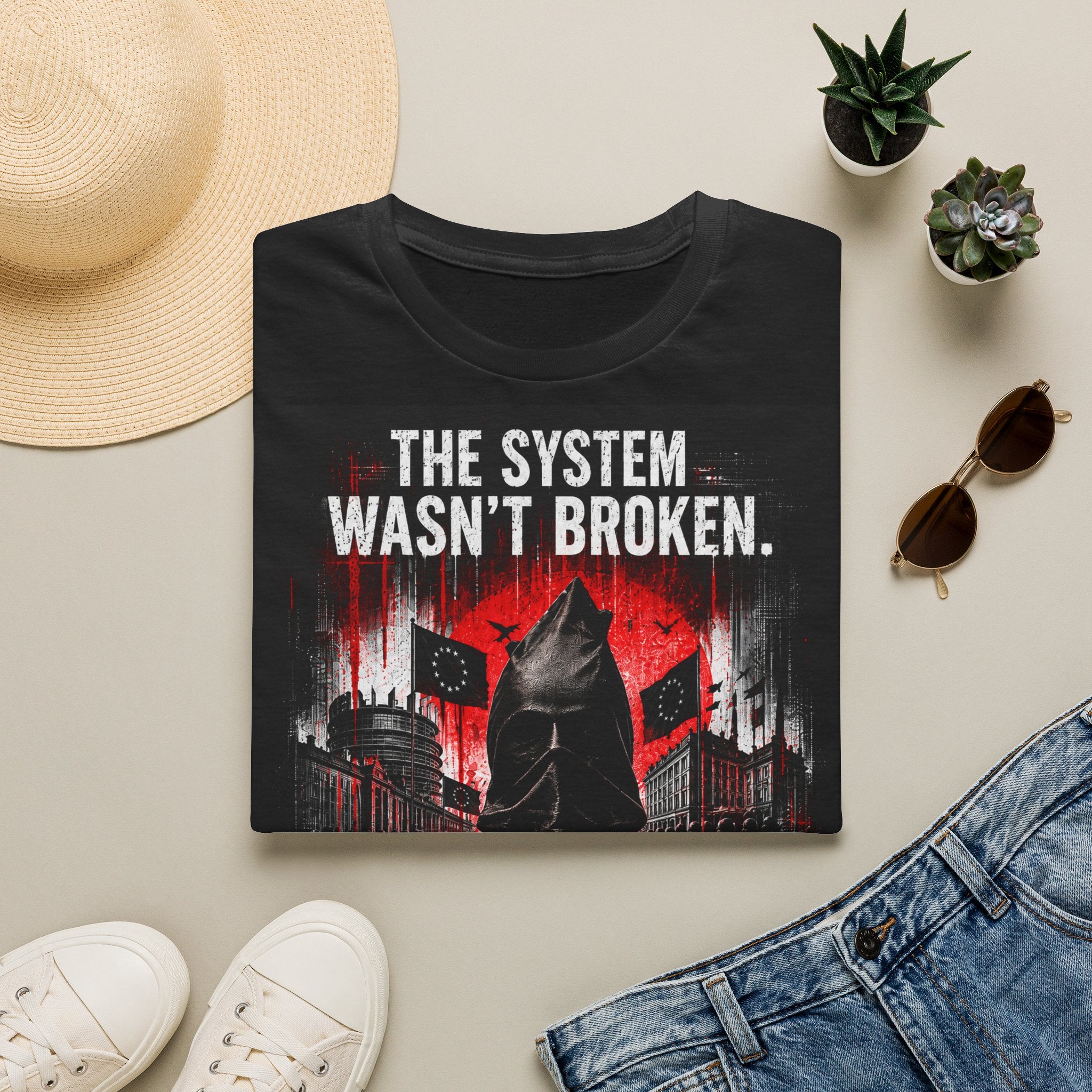 T-Shirt — “The System Wasn’t Broken. It Was Built This Way.” Graphic Tee
