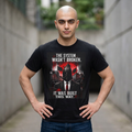 T-Shirt — “The System Wasn’t Broken. It Was Built This Way.” Graphic Tee